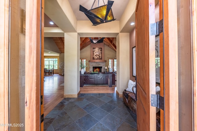 48 Rose Creek Ln, Reno, NV 89511 - foyer featuring a stone fireplace, vaulted ceiling, recessed lighting, and dark stone finish floors