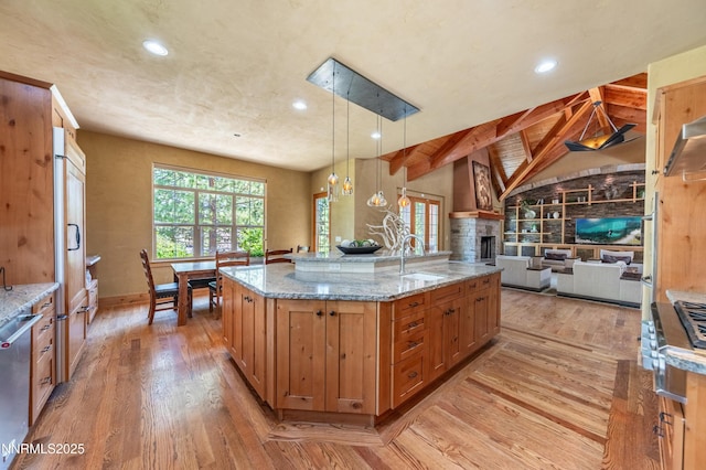 48 Rose Creek Ln, Reno, NV 89511 - kitchen with light wood-style flooring, recessed lighting, a fireplace, open floor plan, and light stone counters
