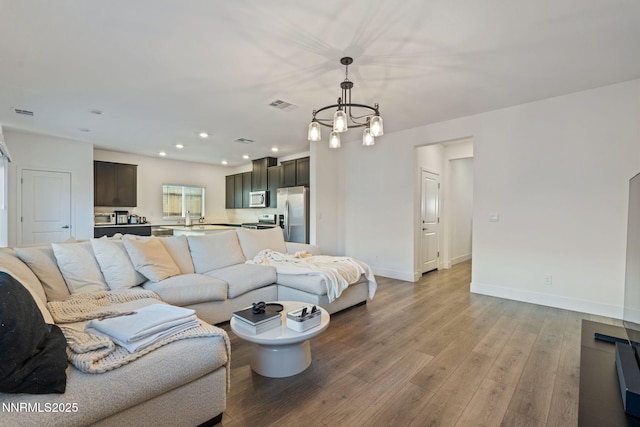 1413 Solitude Trl, Reno, NV 89523 - living area featuring light wood-type flooring, a chandelier, and recessed lighting