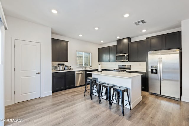 1413 Solitude Trl, Reno, NV 89523 - kitchen featuring stainless steel appliances, a breakfast bar area, light wood-type flooring, a center island, and recessed lighting