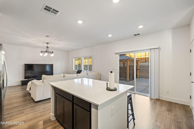 1413 Solitude Trl, Reno, NV 89523 - kitchen with light countertops, a chandelier, light wood-style floors, a kitchen island, and recessed lighting