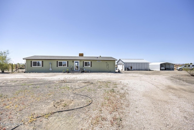 6297 Cox Rd, Fallon, NV 89406 - ranch-style home featuring a detached carport, an outbuilding, dirt driveway, and a chimney