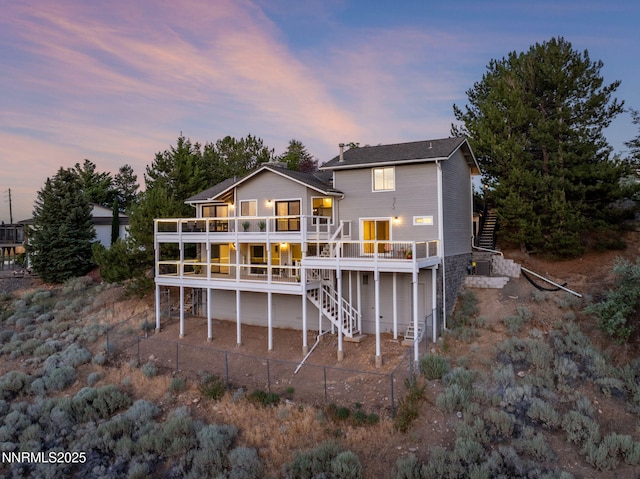 3575 Cashill Blvd, Reno, NV 89509 - back of house at dusk featuring stairway, a fenced backyard, a deck, and a patio