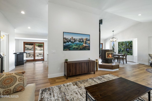 3575 Cashill Blvd, Reno, NV 89509 - living area with a wood stove, healthy amount of natural light, wood finished floors, vaulted ceiling, and recessed lighting