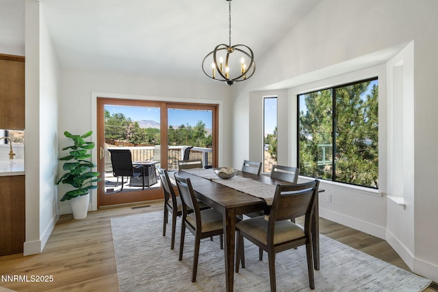 3575 Cashill Blvd, Reno, NV 89509 - dining area with a chandelier, vaulted ceiling, and light wood finished floors