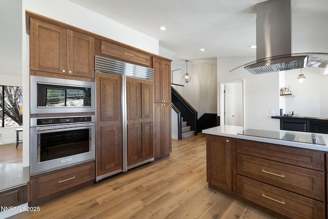 3575 Cashill Blvd, Reno, NV 89509 - kitchen featuring built in appliances, island exhaust hood, light wood finished floors, recessed lighting, and hanging light fixtures