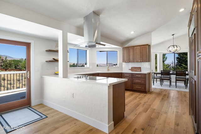 3575 Cashill Blvd, Reno, NV 89509 - kitchen with island range hood, black electric stovetop, lofted ceiling, plenty of natural light, and a peninsula