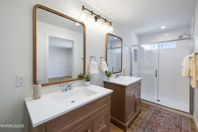 3575 Cashill Blvd, Reno, NV 89509 - bathroom with a stall shower, two vanities, wood finished floors, and recessed lighting