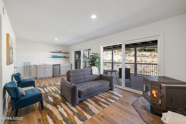 3575 Cashill Blvd, Reno, NV 89509 - living room featuring bar area, a wood stove, light wood-type flooring, and recessed lighting