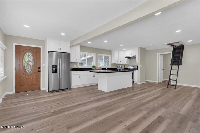1094 Johnson Blvd, South Lake Tahoe, CA 96150 - kitchen with appliances with stainless steel finishes, dark countertops, under cabinet range hood, white cabinetry, and recessed lighting
