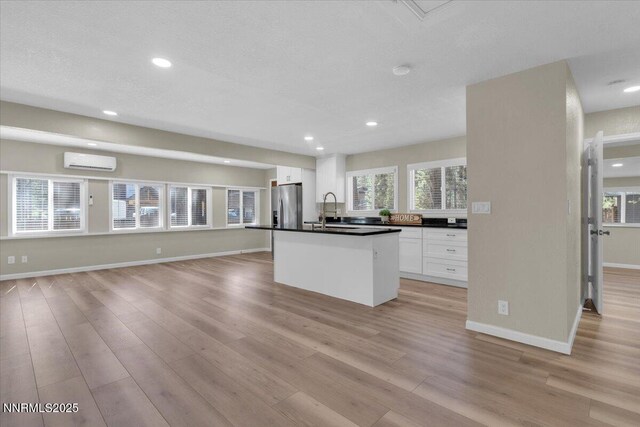 1094 Johnson Blvd, South Lake Tahoe, CA 96150 - kitchen featuring a wall mounted air conditioner, stainless steel refrigerator with ice dispenser, white cabinetry, light wood-style flooring, and recessed lighting