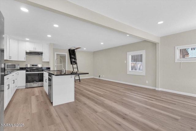 1094 Johnson Blvd, South Lake Tahoe, CA 96150 - kitchen with stainless steel appliances, exhaust hood, dark countertops, white cabinetry, and light wood finished floors