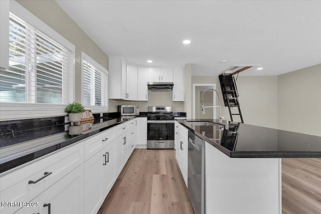 1094 Johnson Blvd, South Lake Tahoe, CA 96150 - kitchen featuring appliances with stainless steel finishes, dark countertops, light wood finished floors, extractor fan, and recessed lighting