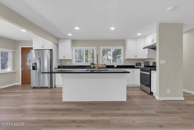 1094 Johnson Blvd, South Lake Tahoe, CA 96150 - kitchen with appliances with stainless steel finishes, under cabinet range hood, dark countertops, white cabinetry, and recessed lighting
