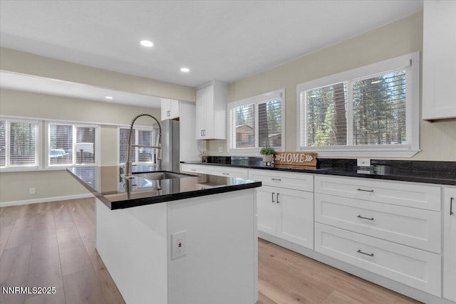 1094 Johnson Blvd, South Lake Tahoe, CA 96150 - kitchen featuring light wood-style flooring, a center island with sink, white cabinetry, dark countertops, and recessed lighting