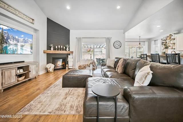 3287 Hackamore Way, Winnemucca, NV 89445 - living area featuring a glass covered fireplace, vaulted ceiling, a chandelier, wood finished floors, and recessed lighting