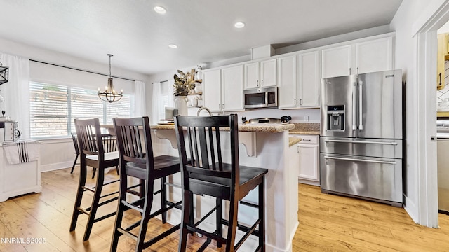 3287 Hackamore Way, Winnemucca, NV 89445 - kitchen featuring appliances with stainless steel finishes, a chandelier, light wood finished floors, white cabinets, and recessed lighting