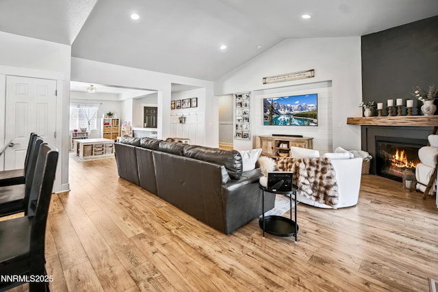 3287 Hackamore Way, Winnemucca, NV 89445 - living area with a glass covered fireplace, vaulted ceiling, light wood-style flooring, recessed lighting, and built in shelves