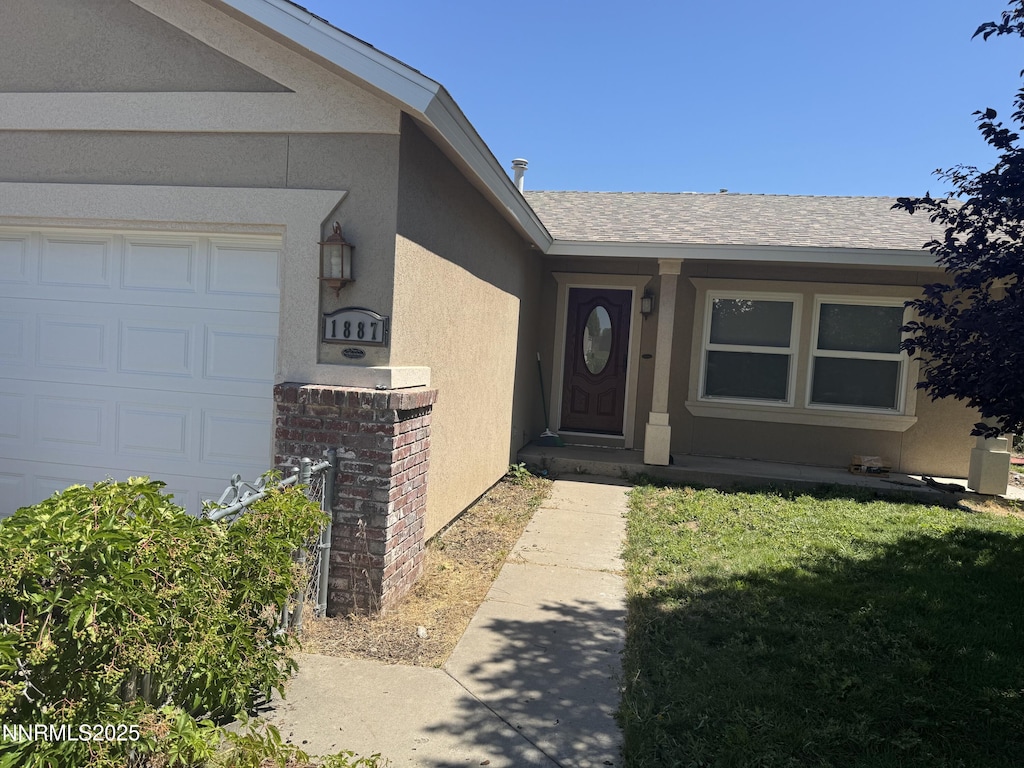 1887 Scott St, Winnemucca, NV 89445 - doorway to property with stucco siding, roof with shingles, and a garage