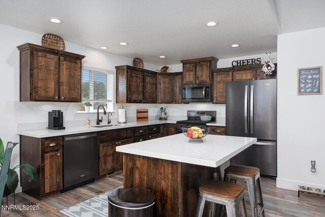 776 Kinsli St, Fallon, NV 89406 - kitchen with stainless steel appliances, dark brown cabinets, dark wood-style flooring, light countertops, and a center island