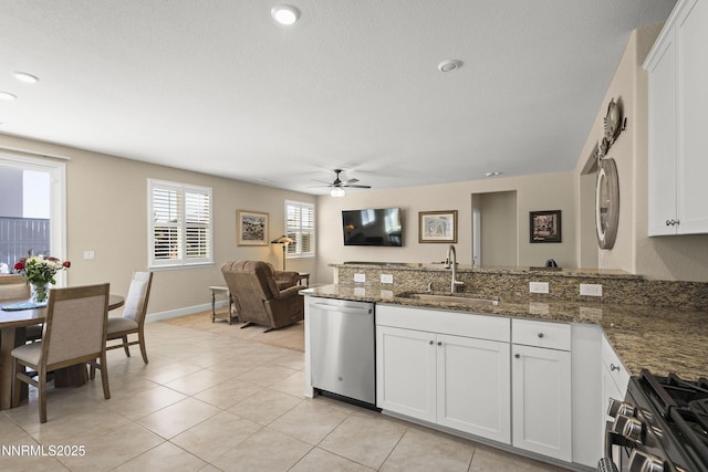 7106 Owl Vw Dr, Sparks, NV 89436 - kitchen featuring stainless steel dishwasher, a peninsula, ceiling fan, gas stove, and white cabinetry