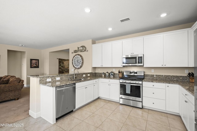 7106 Owl Vw Dr, Sparks, NV 89436 - kitchen featuring stainless steel appliances, a peninsula, open floor plan, white cabinets, and recessed lighting