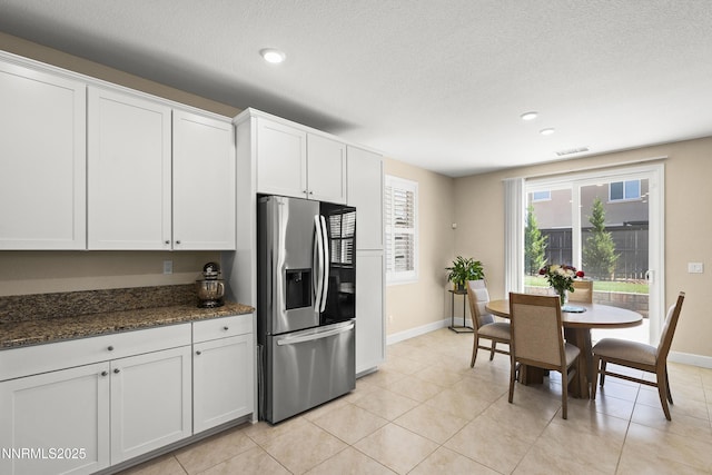 7106 Owl Vw Dr, Sparks, NV 89436 - kitchen featuring stainless steel fridge, recessed lighting, white cabinetry, dark stone countertops, and light tile patterned floors