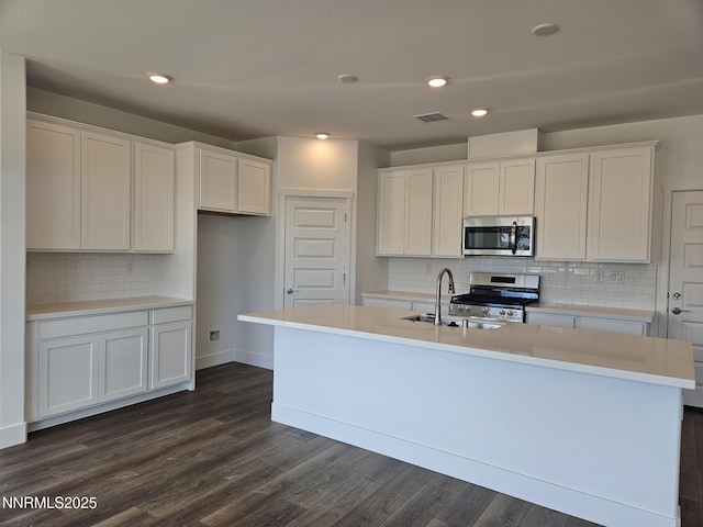 1219 Heybourne Rd, Gardnerville, NV 89410 - kitchen featuring appliances with stainless steel finishes, a center island with sink, white cabinets, backsplash, and recessed lighting