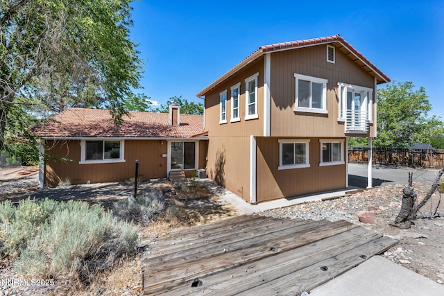 1425 Julie Ct, Reno, NV 89509 - back of property featuring a tiled roof, a wooden deck, and a chimney