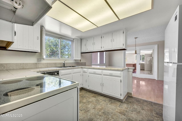 1425 Julie Ct, Reno, NV 89509 - kitchen featuring freestanding refrigerator, a peninsula, white cabinets, ventilation hood, and light countertops