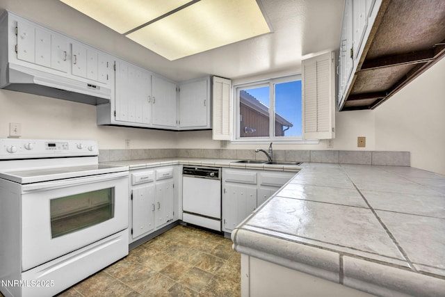 1425 Julie Ct, Reno, NV 89509 - kitchen with white appliances, custom range hood, tile counters, and stone finish floors