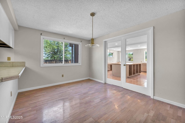 1425 Julie Ct, Reno, NV 89509 - unfurnished dining area with light wood-type flooring and a textured ceiling