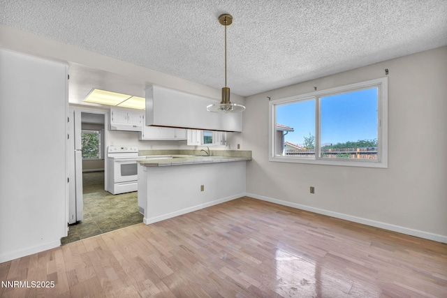 1425 Julie Ct, Reno, NV 89509 - kitchen featuring electric stove, a peninsula, light wood-style flooring, a textured ceiling, and white cabinets