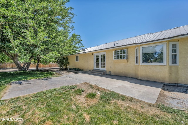 4210 Magnolia Rd, Fallon, NV 89406 - rear view of property featuring stucco siding, french doors, a patio, a metal roof, and entry steps