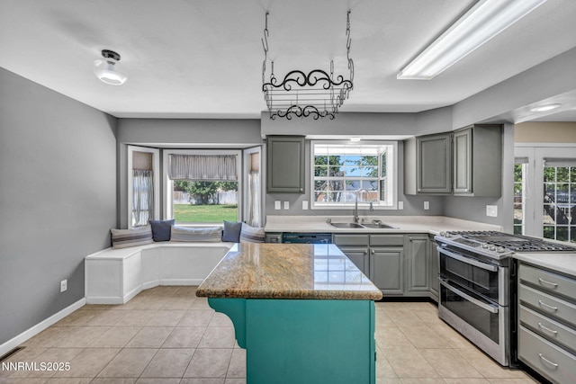 4210 Magnolia Rd, Fallon, NV 89406 - kitchen with range with two ovens, gray cabinetry, and light tile patterned floors