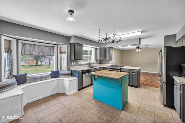 4210 Magnolia Rd, Fallon, NV 89406 - kitchen featuring appliances with stainless steel finishes, a kitchen island, light tile patterned floors, ceiling fan, and gray cabinets