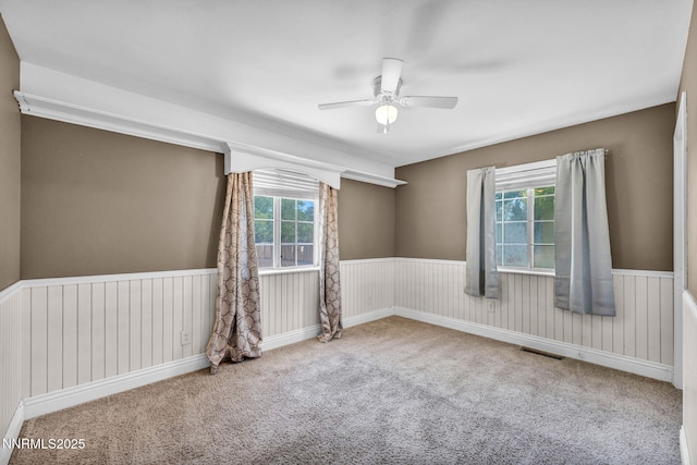 4210 Magnolia Rd, Fallon, NV 89406 - empty room with healthy amount of natural light, carpet, ceiling fan, and a wainscoted wall