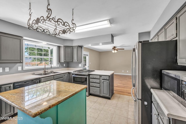 4210 Magnolia Rd, Fallon, NV 89406 - kitchen with stainless steel appliances, gray cabinets, a center island, light tile patterned flooring, and a ceiling fan