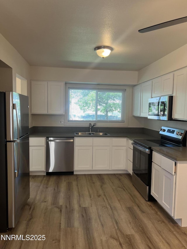 385 Smithridge Park Unit 3Ut4Lt, Reno, NV 89502 - kitchen featuring stainless steel appliances, wood finished floors, dark countertops, and white cabinetry