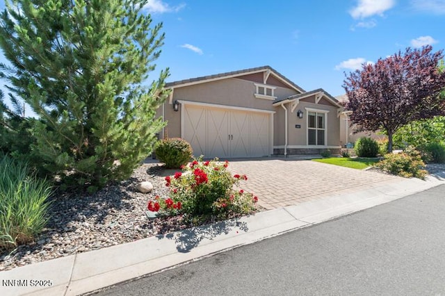 1460 Waterloo Dr, Reno, NV 89509 - view of front of home featuring an attached garage, stucco siding, and decorative driveway