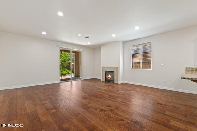 1460 Waterloo Dr, Reno, NV 89509 - unfurnished living room with a tiled fireplace, dark wood-style flooring, and recessed lighting
