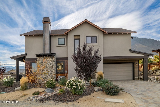 2912 Portrush Dr, Genoa, NV 89411 - view of front facade featuring stucco siding, an attached garage, stone siding, decorative driveway, and a mountain view