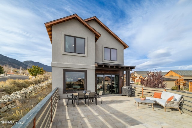 2912 Portrush Dr, Genoa, NV 89411 - rear view of house with stucco siding, a mountain view, a patio, and outdoor dining space