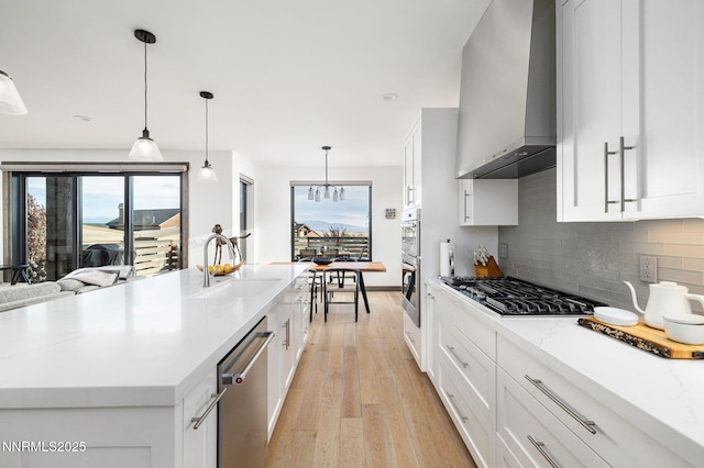 2912 Portrush Dr, Genoa, NV 89411 - kitchen featuring wall chimney exhaust hood, stainless steel appliances, decorative backsplash, light wood-style floors, and light stone countertops