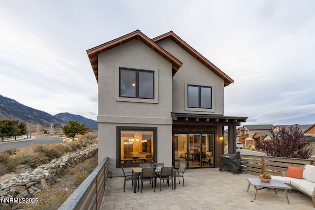2912 Portrush Dr, Genoa, NV 89411 - back of property featuring stucco siding, a mountain view, a patio area, and outdoor dining space
