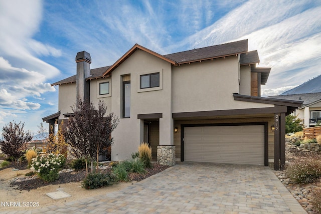 2912 Portrush Dr, Genoa, NV 89411 - view of front of house with a garage, stucco siding, a chimney, driveway, and stone siding