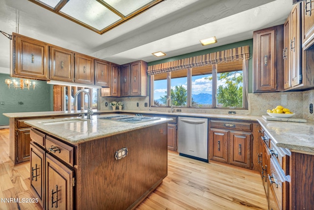 1405 Primrose Ln, Minden, NV 89423 - kitchen featuring stainless steel dishwasher, light wood-type flooring, a center island with sink, and backsplash