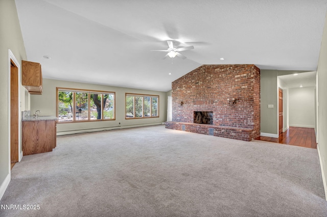 1405 Primrose Ln, Minden, NV 89423 - unfurnished living room with a baseboard heating unit, a ceiling fan, lofted ceiling, carpet flooring, and a brick fireplace