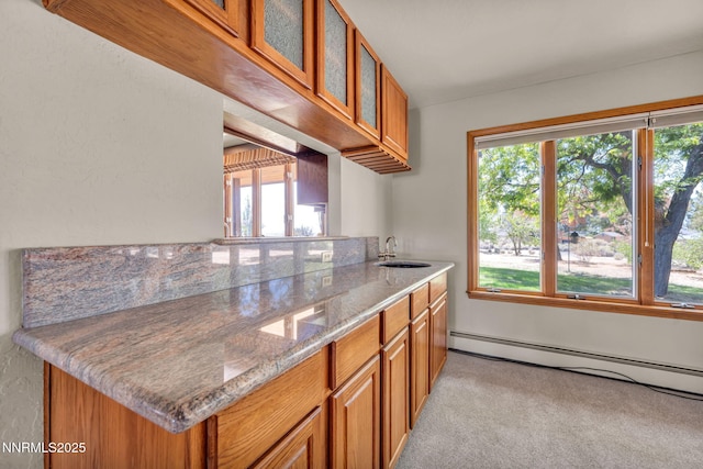 1405 Primrose Ln, Minden, NV 89423 - kitchen featuring baseboard heating, brown cabinets, light colored carpet, and glass insert cabinets