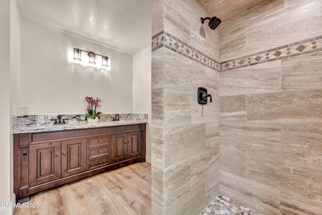 1405 Primrose Ln, Minden, NV 89423 - bathroom featuring tiled shower, wood finished floors, and double vanity